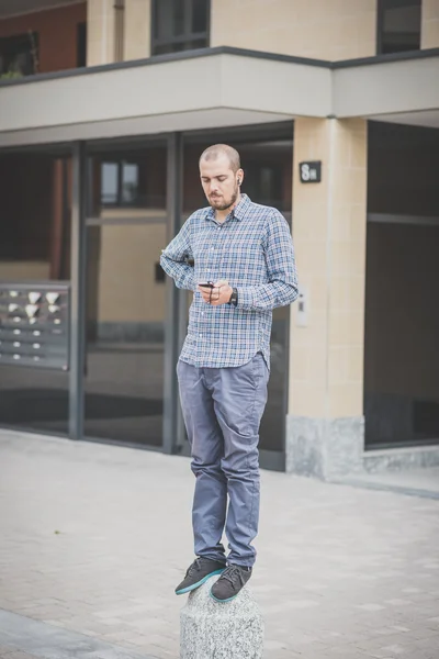 Knappe hipster casual multitasking moderne mens gebruikend smartphone — Stockfoto