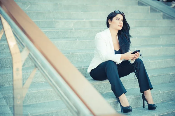 Piękne długie, czarne włosy elegancki kobieta za pomocą smartphon — Zdjęcie stockowe