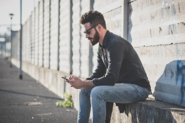 akıllı telefon kullanan genç yakışıklı çekici sakallı model adam