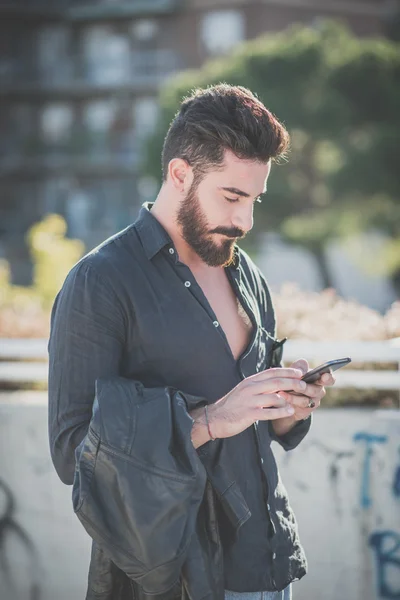 Uomo modello barbuto utilizzando smartphone — Foto Stock