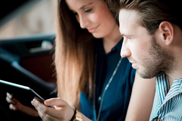 Jóvenes amantes de la pareja hermosa usando tableta — Foto de Stock