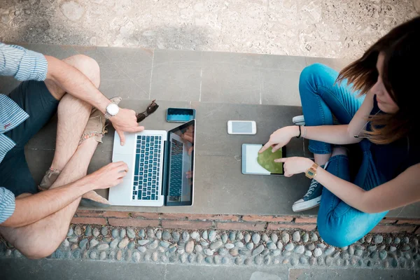 Young couple using technology multitasking smarpthone tablet and — Stock Photo, Image