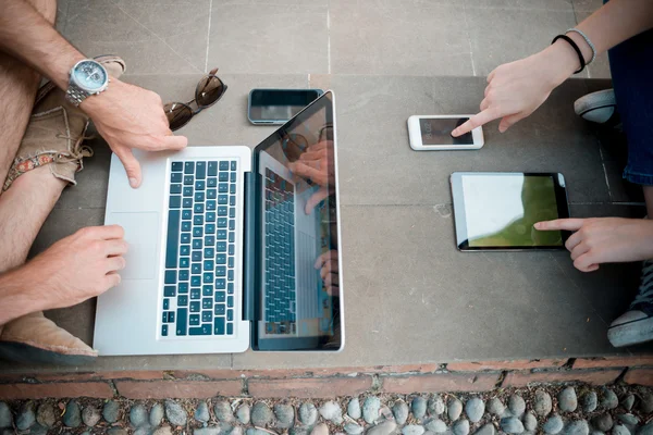 Ungt par använder teknik multitasking smarpthone tablett och — Stockfoto