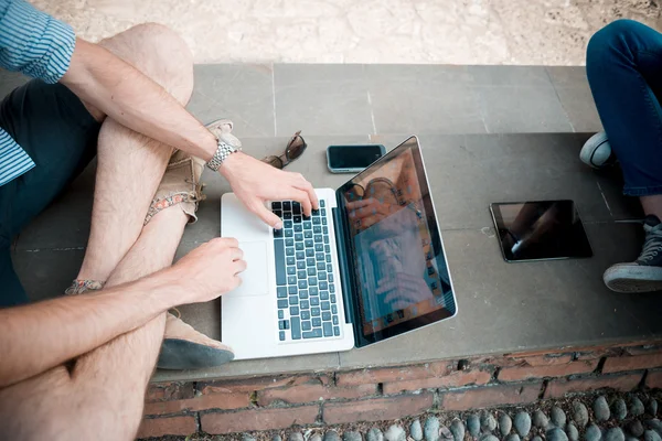 Jong koppel met behulp van technologie multitasking smarpthone Tablet PC en — Stockfoto
