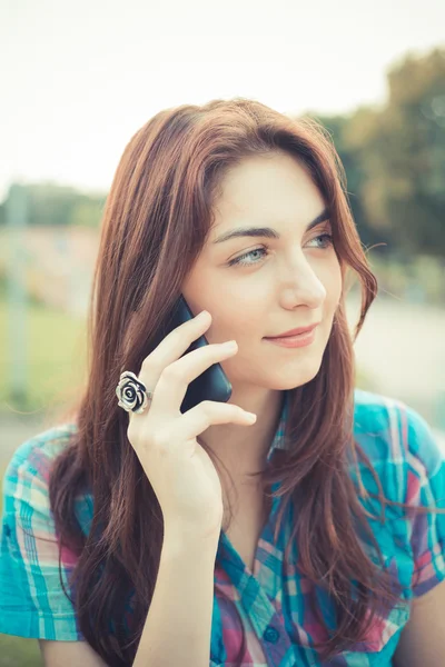 Hermosa joven hipster mujer usando teléfono inteligente — Foto de Stock