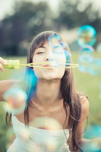 Krásná mladá žena s bílými šaty foukání bublin — Stock fotografie