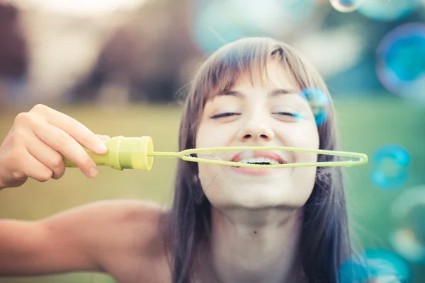 Kabarcık üfleme beyaz elbise ile güzel genç kadın — Stok fotoğraf