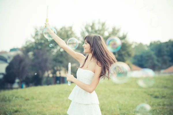 Hermosa joven con vestido blanco soplando burbuja —  Fotos de Stock