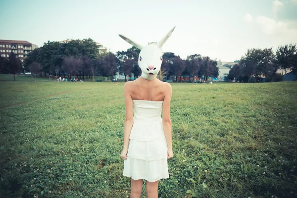 Rabbit mask absurd beautiful young woman with white dress — Stock Photo, Image