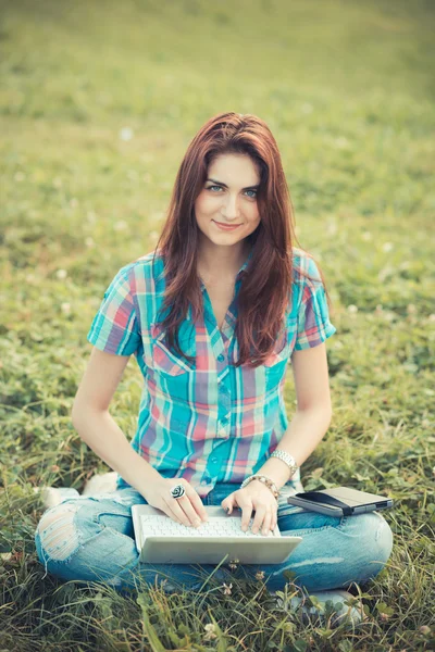 Hermosa mujer joven hipster utilizando el ordenador portátil y tableta — Foto de Stock