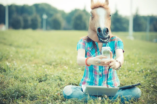 Máscara de cavalo mulher hipster irreal usando a tecnologia — Fotografia de Stock