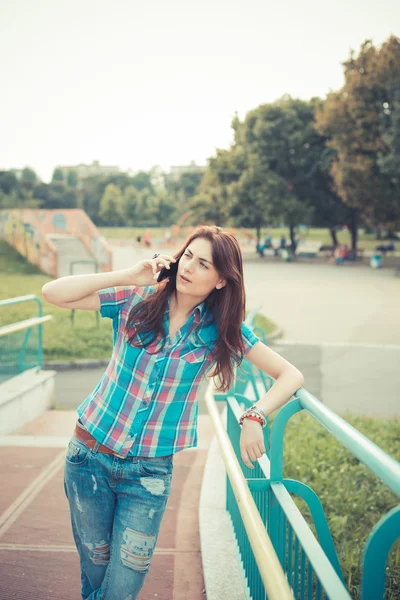 Hermosa joven hipster mujer usando teléfono inteligente — Foto de Stock