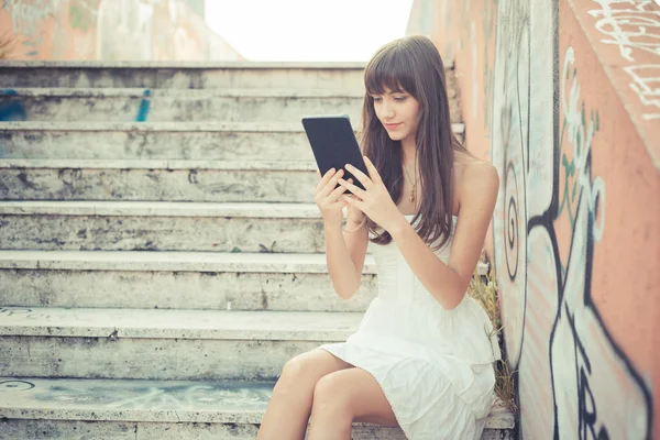 Wanita muda cantik dengan gaun putih menggunakan tablet — Stok Foto