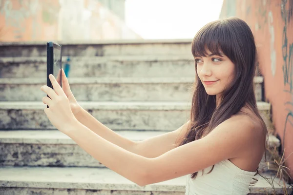 Belle jeune femme avec robe blanche en utilisant une tablette — Photo