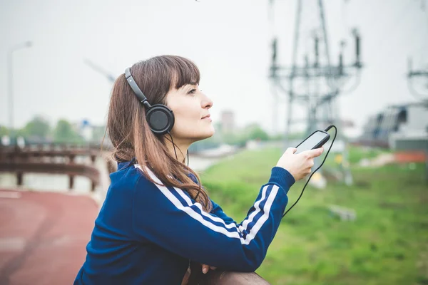 Femeie frumoasă folosind telefonul inteligent și ascultând muzică — Fotografie, imagine de stoc
