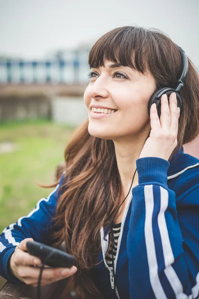 Mulher bonita usando telefone inteligente e ouvir música — Fotografia de Stock