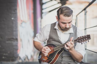 yakışıklı büyük bıyık hipster adam mandolin çalmaya