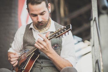 yakışıklı büyük bıyık hipster adam mandolin çalmaya