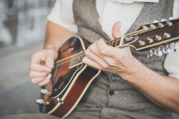 close up hands hipster man playing mandolin
