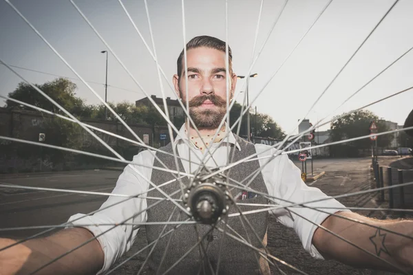 Handsome big moustache hipster man holding old bicycle wheel — Stock Photo, Image