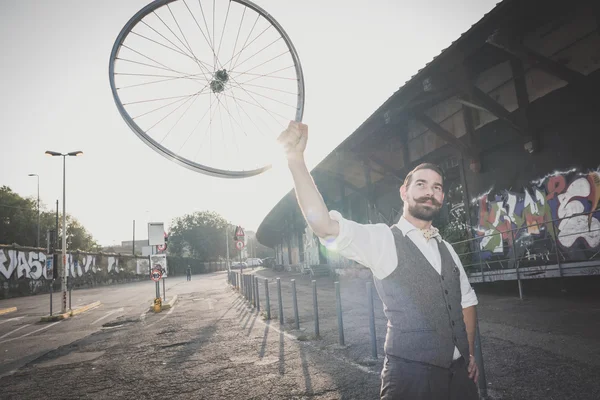 Handsome big moustache hipster man holding old bicycle wheel — Stock Photo, Image