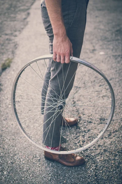 古い自転車の車輪を抱きかかえた脚靴ヒップスターのクローズ アップ — ストック写真