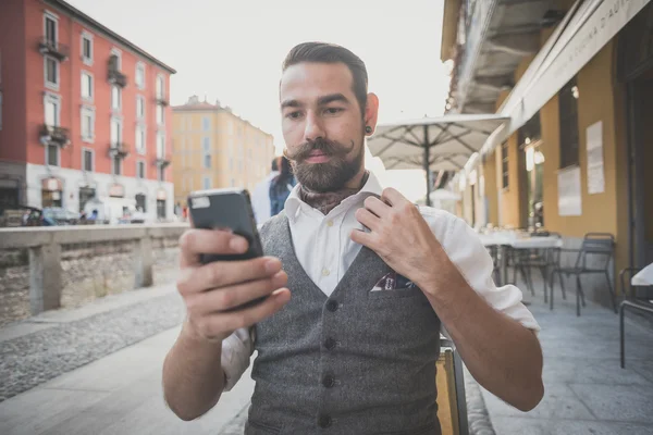 Guapo bigote grande hipster hombre usando el teléfono inteligente — Foto de Stock