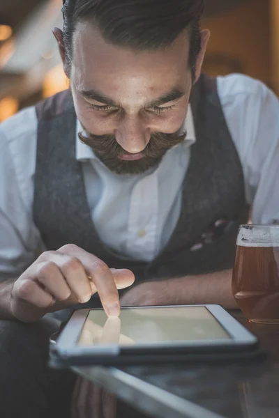 Άνθρωπος hipster όμορφος μεγάλο μουστάκι χρήση ταμπλετών — Φωτογραφία Αρχείου