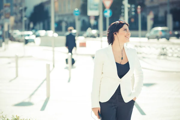 Elegante donna d'affari con auricolari — Foto Stock