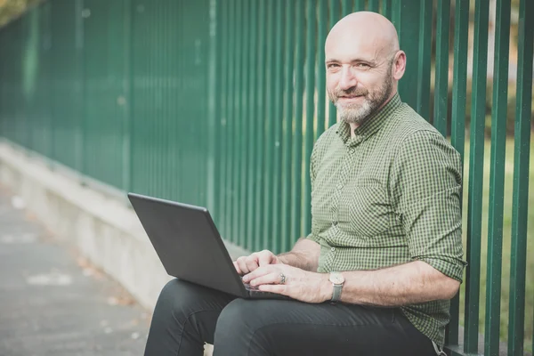 Bonito homem de meia idade usando notebook — Fotografia de Stock