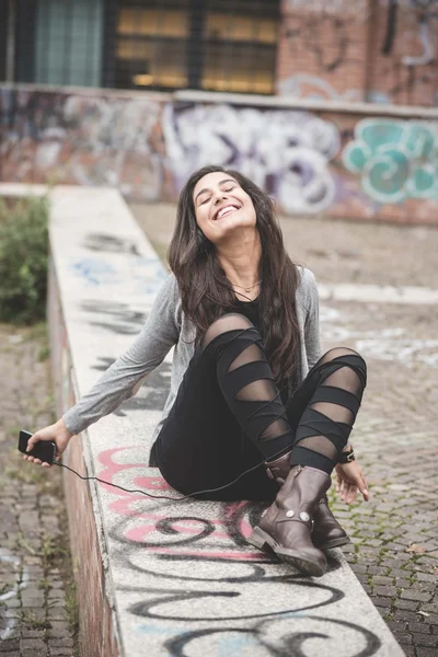 Vrouw luisteren muziek in de stad — Stockfoto