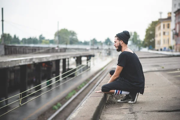 Hipster man sitter på gatan — Stockfoto