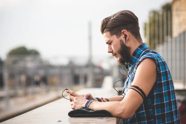 Giovane uomo che ascolta musica con auricolari — Foto Stock