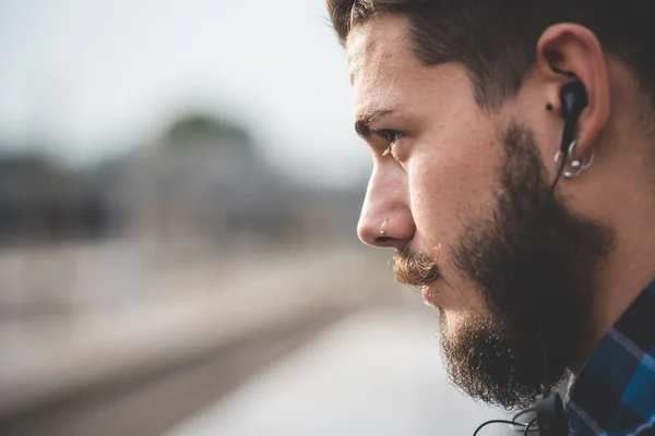 Joven escuchando música con auriculares — Foto de Stock