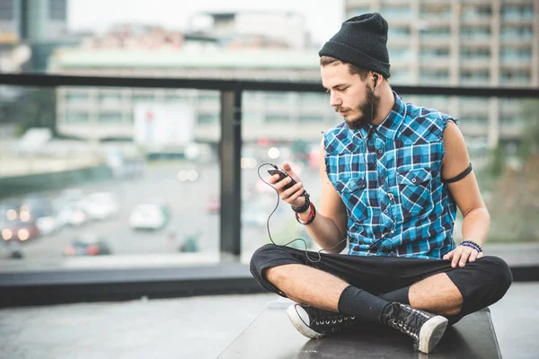 Hombre barbudo escuchando música en la ciudad — Foto de Stock