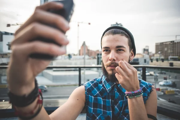 Brodaty mężczyzna biorąc selfie w mieście — Zdjęcie stockowe