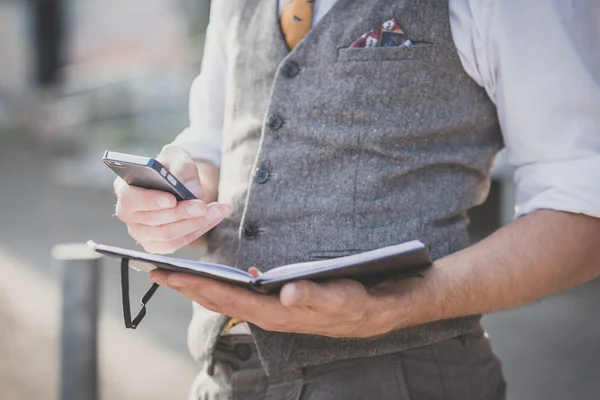 Hipster człowieka za pomocą pamiętnik i smartphone — Zdjęcie stockowe