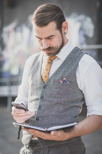 Hipster man using diary and smartphone — Stock Photo, Image