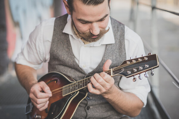 Man with big moustache playing mandolin