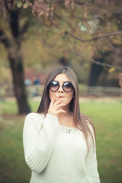 Jeune femme avec cigarette en plein air — Photo