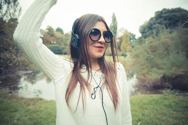 音楽を聴く若いブルネットの女性 — ストック写真