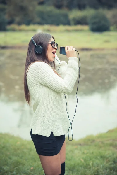 Jonge brunette vrouw luisteren muziek — Stockfoto
