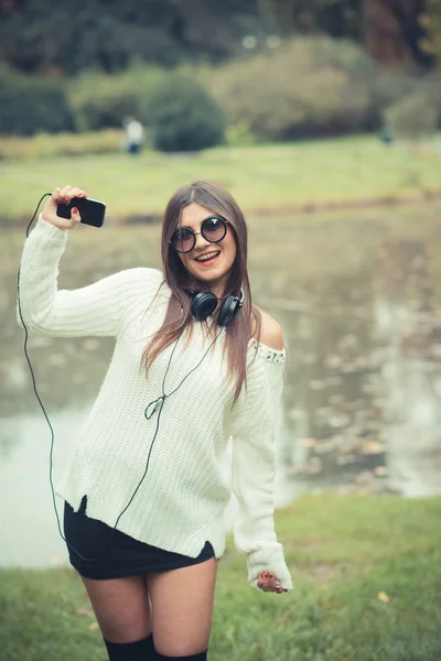 Mujer morena joven con auriculares — Foto de Stock