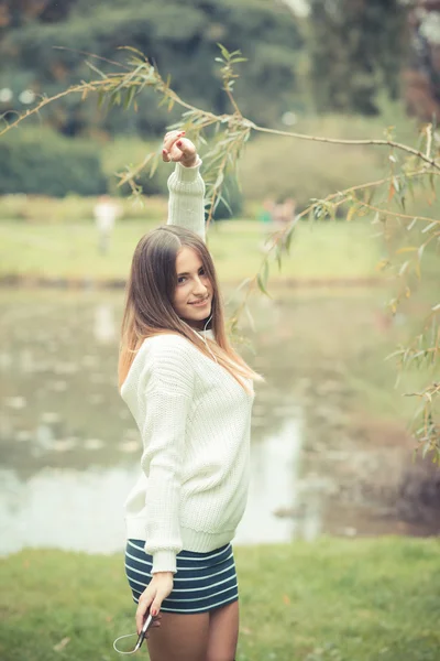 Jonge vrouw luisteren muziek in park — Stockfoto