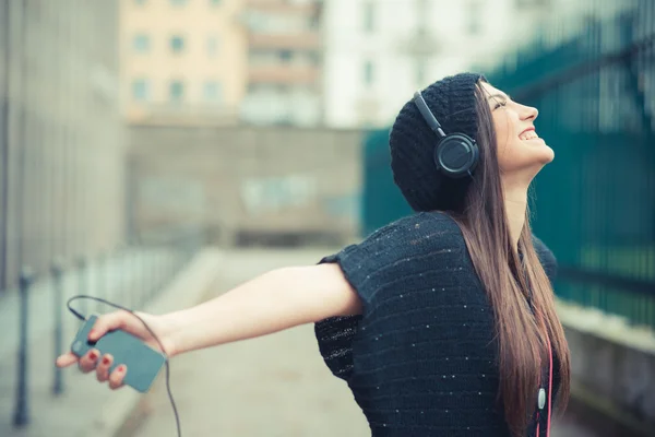 Gek brunette vrouw luisteren muziek — Stockfoto