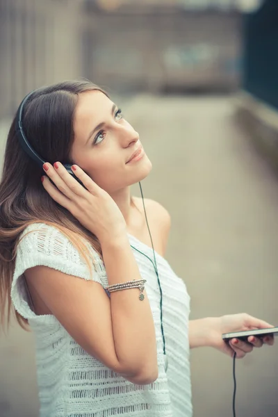 Junge schöne Frau hört Musik — Stockfoto