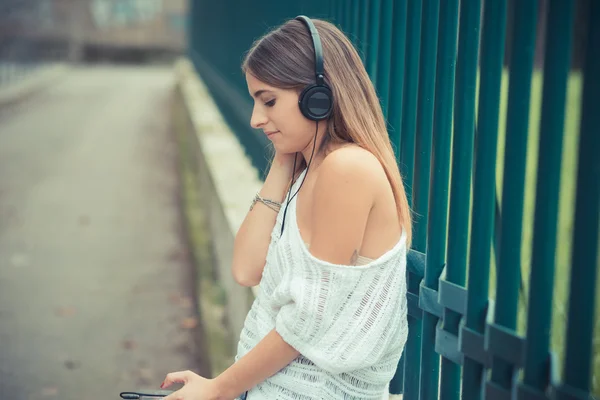 Junge schöne Frau hört Musik — Stockfoto