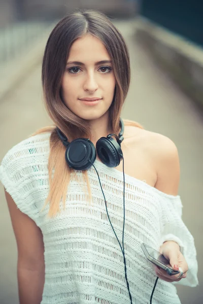 Młoda kobieta z zewnątrz słuchawki — Zdjęcie stockowe