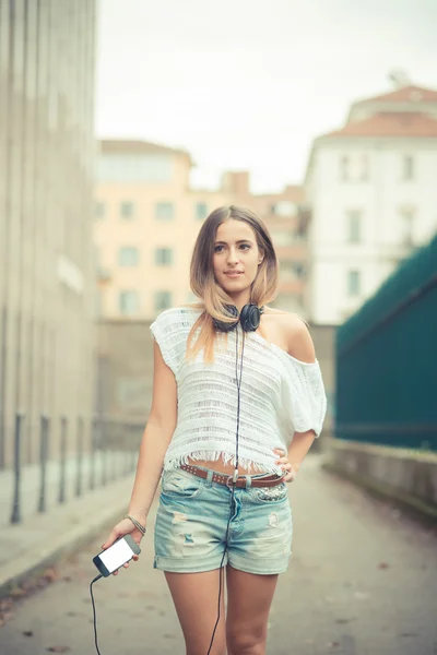 Mujer joven con auriculares al aire libre — Foto de Stock