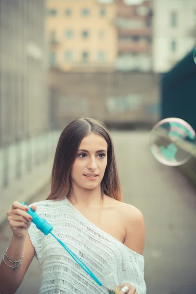 Женщина выдувает пузырьки суп на открытом воздухе — стоковое фото